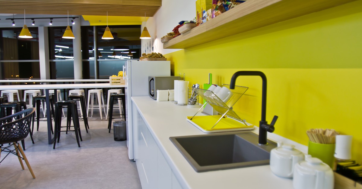 A counter with various items on it, such as plates, jars, and a microwave. There is also a sink in the counter.